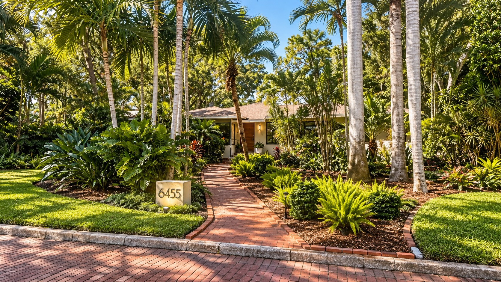 Single-story Lake Pasadena home set behind palms and tropical landscaping